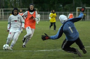 Tehran, IRAN: Iran's women national football player, Fereshteh Karimi (L), scores a goal as Germany's Al-Dersimspor, Friederike Scmitd (C), and goalkeeper, Paraskewi Boras (R), try to catch the ball during their second friendly match at Tehran's Ararat s